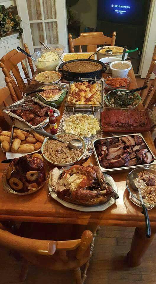 a table full of food that is sitting on top of a wooden dining room table