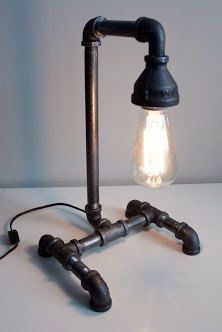 a lamp made out of pipes with a light bulb on top