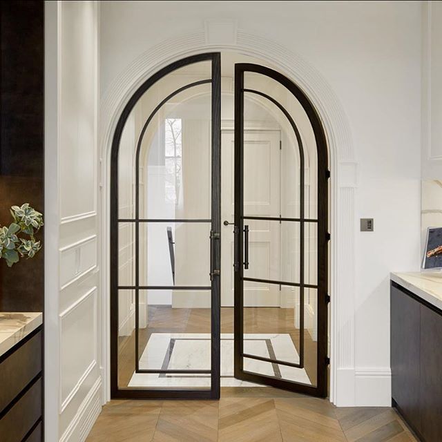 an arched glass door leading to a kitchen