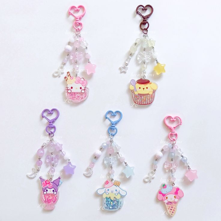 several different shaped key chains with charms attached to them on a white surface in the shape of cupcakes