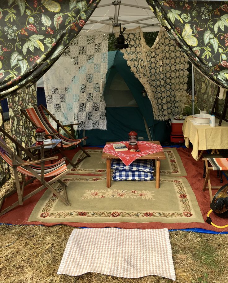 the inside of a tent with chairs and rugs on the ground in front of it