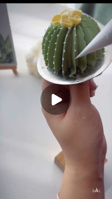 a person holding a plate with a cactus on it and a knife sticking out of the top