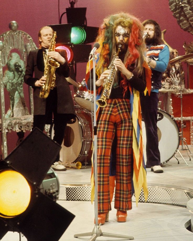 a group of people that are standing in front of some musical instruments on stage with one person dressed as a lion