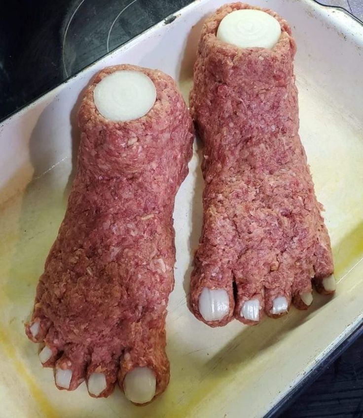 two feet covered in meat sitting on top of a pan