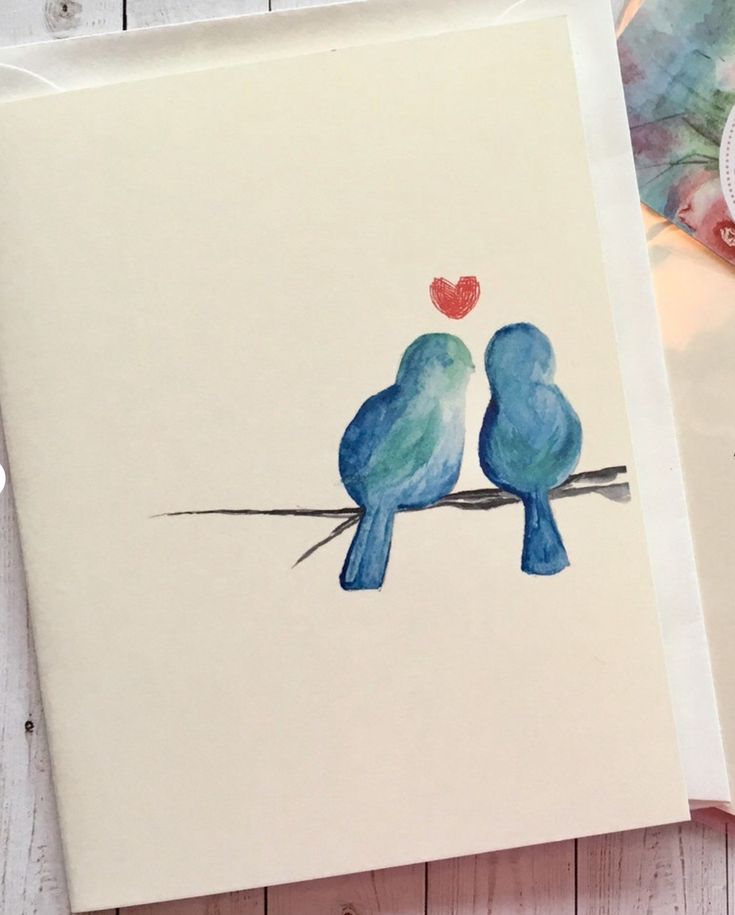 two blue birds sitting on a branch with a heart in their beaks painted on it