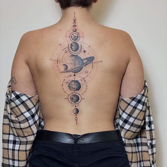 the back of a woman's body with tattoos on her upper and lower back