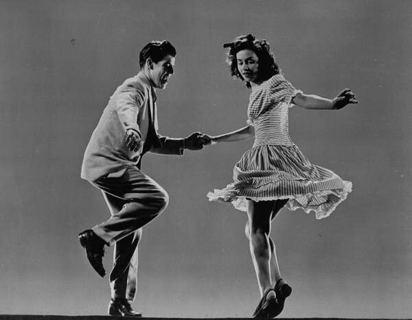 an old photo of two people dancing