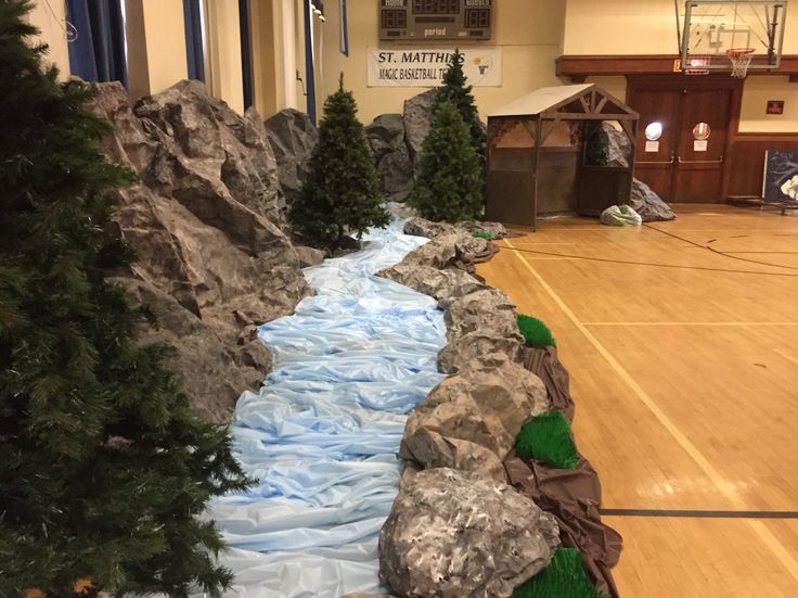 there is a fake river in the middle of this room with rocks and trees around it