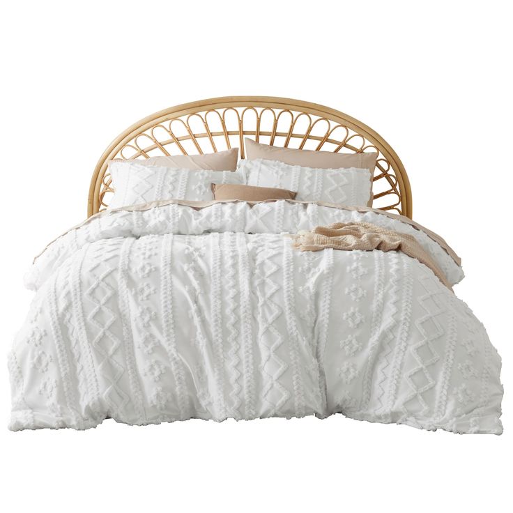 a bed with white comforter and pillows on it's headboard, in front of a white background