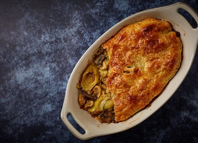 a casserole dish with vegetables in it on a blue tableclothed surface