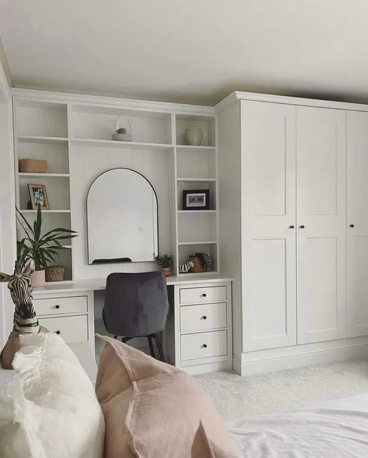 a bedroom with white cabinets and a desk in the corner, along with a bed