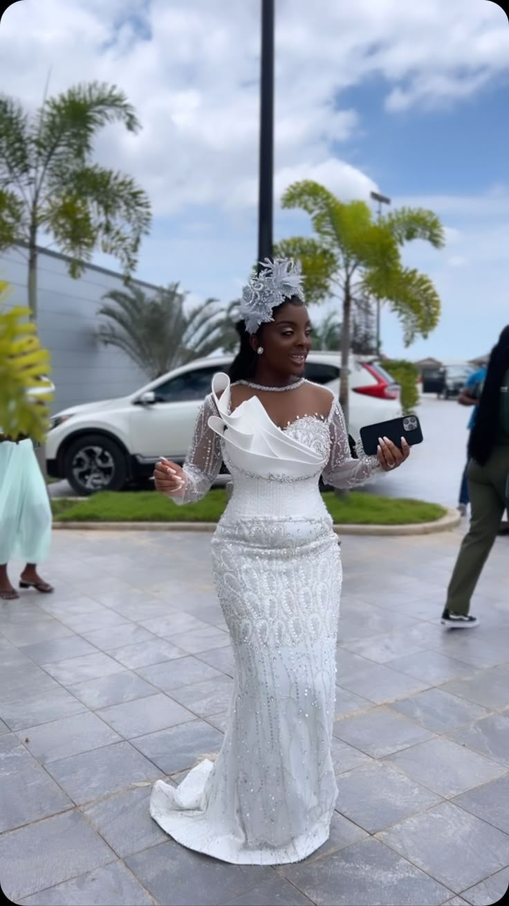 a woman in a white dress is dancing on the street with palm trees behind her