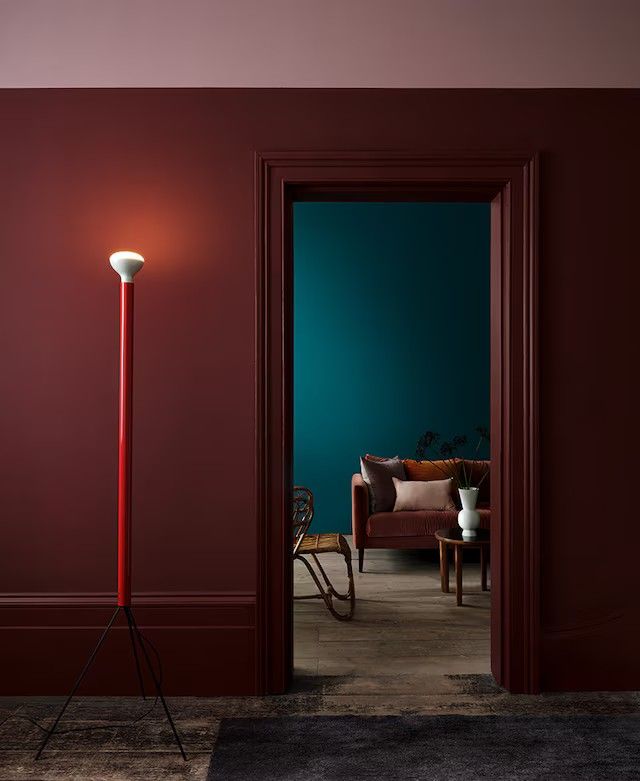 a red floor lamp in the corner of a room