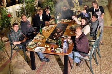 a group of people sitting around a table with food