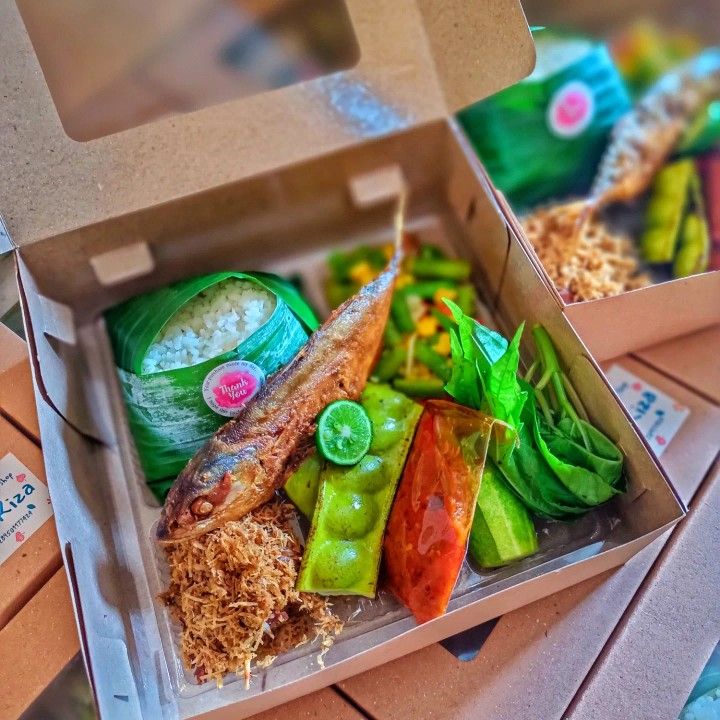 a box filled with lots of different types of food on top of a wooden table