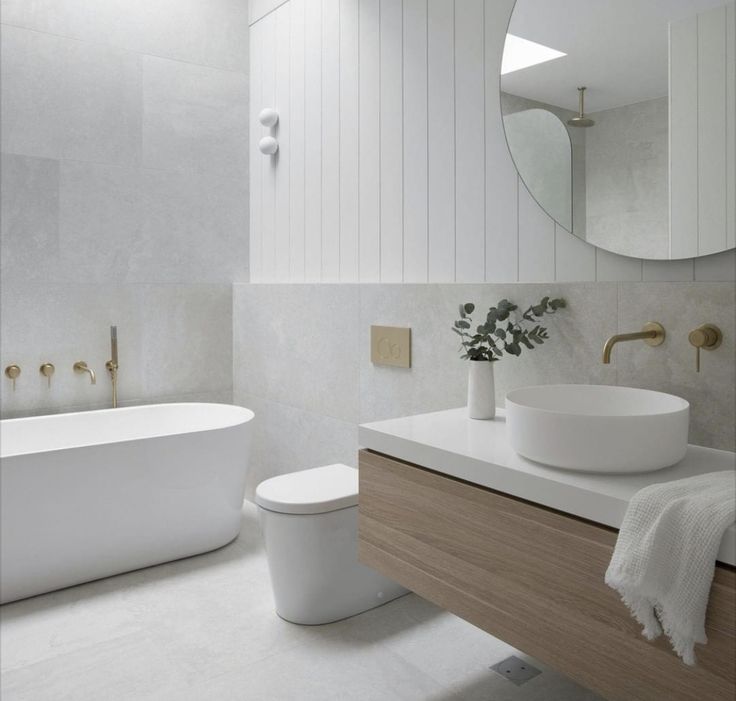 a bathroom with a sink, toilet and bathtub next to a wall mounted mirror