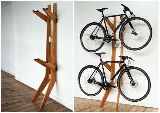 there is a bike mounted to the wall next to a wooden rack with two bikes on it