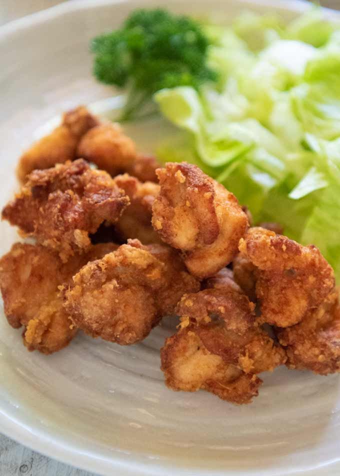 some fried food on a white plate with lettuce