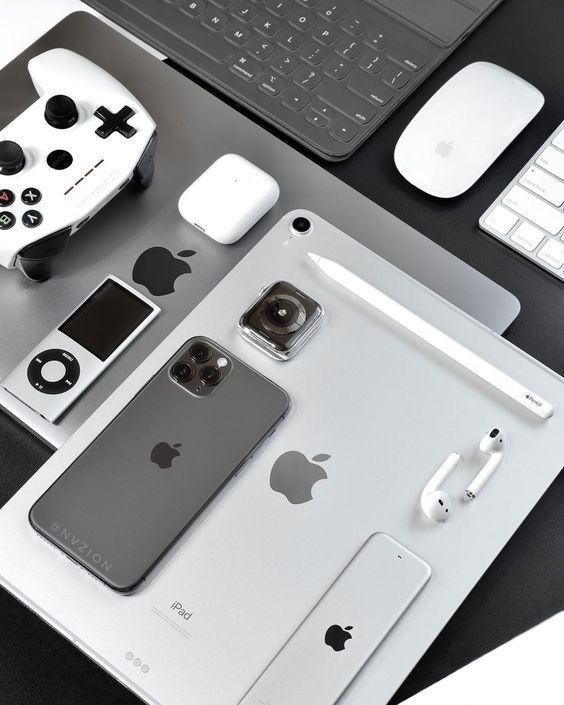 an apple product is displayed on a desk next to a keyboard, mouse and other electronics