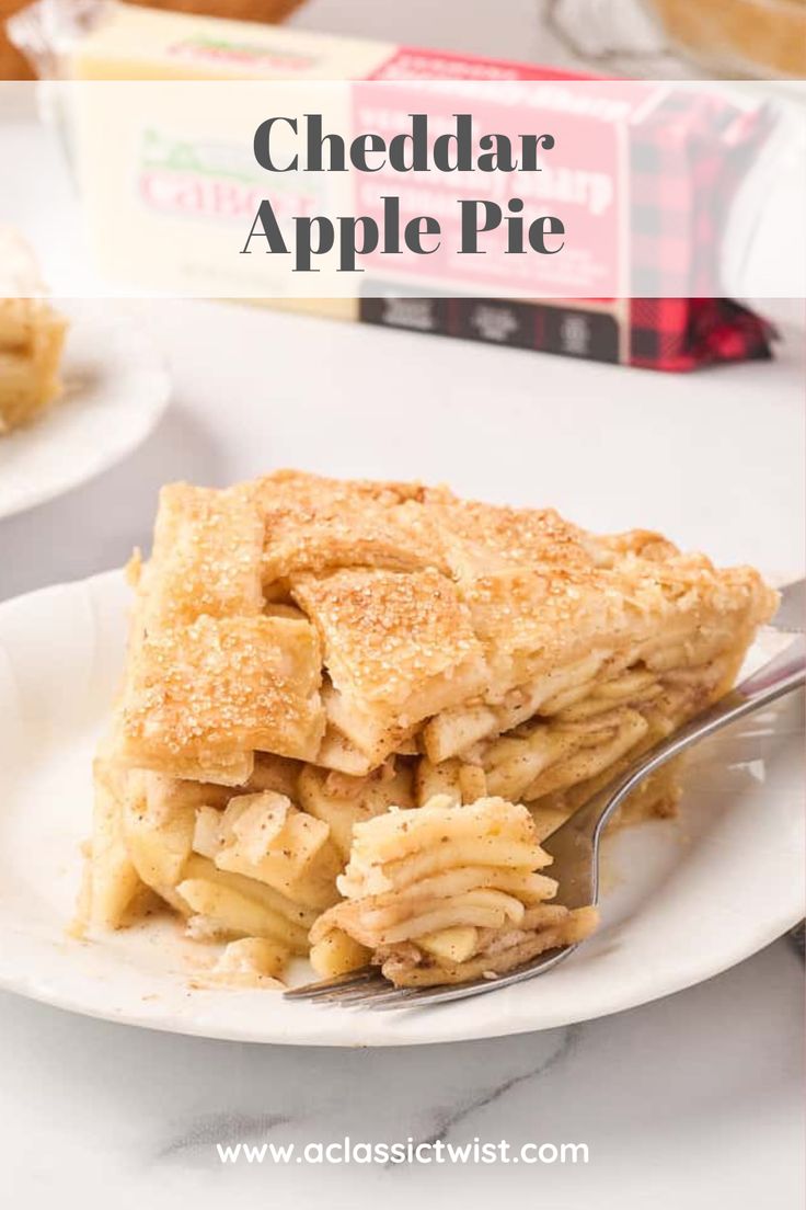 a slice of apple pie on a white plate with a fork and box of cheddar apples in the background