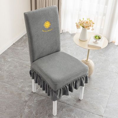 a grey chair with a yellow sun on the back and tassels around it