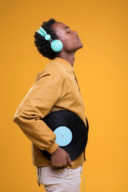 a man wearing headphones and holding a record