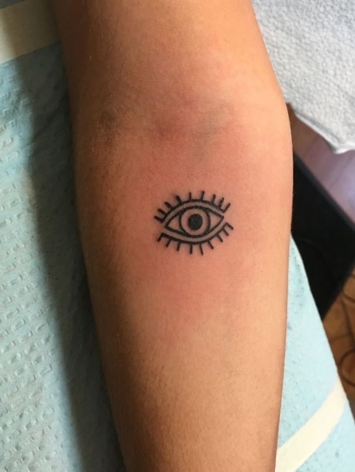 a person with a tattoo on their arm that has an eye in the middle of it