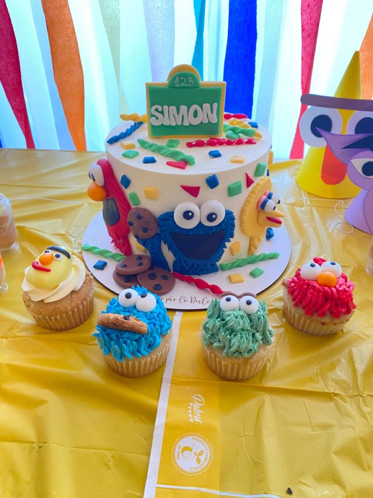 a table topped with lots of cupcakes covered in frosting