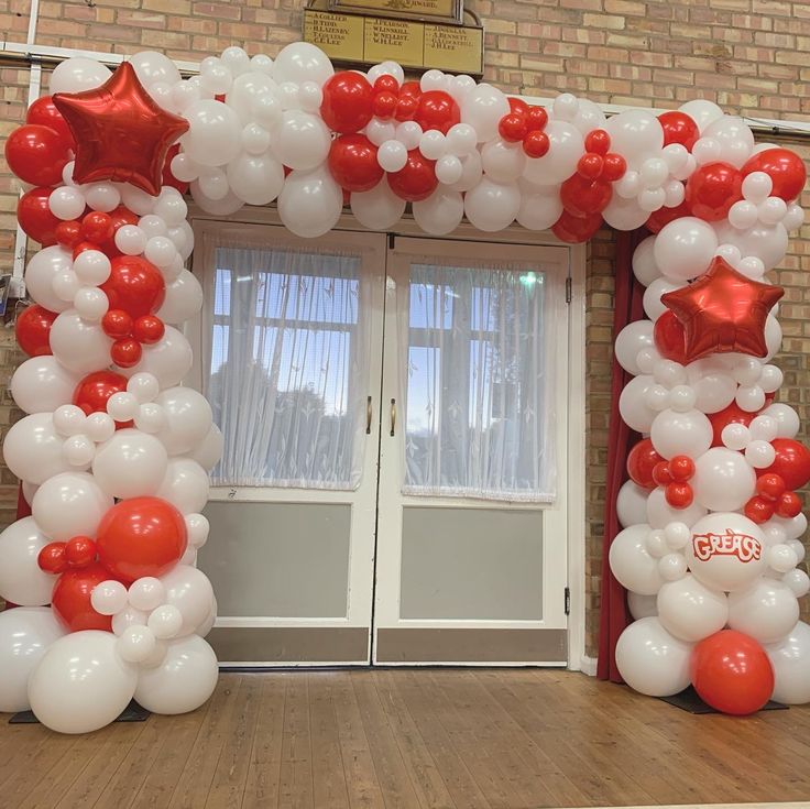 an entrance decorated with red and white balloons