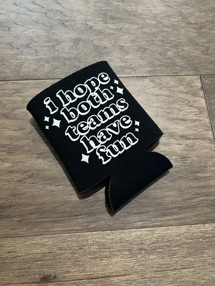 a black case with white writing on it sitting on top of a wooden floor next to a cell phone