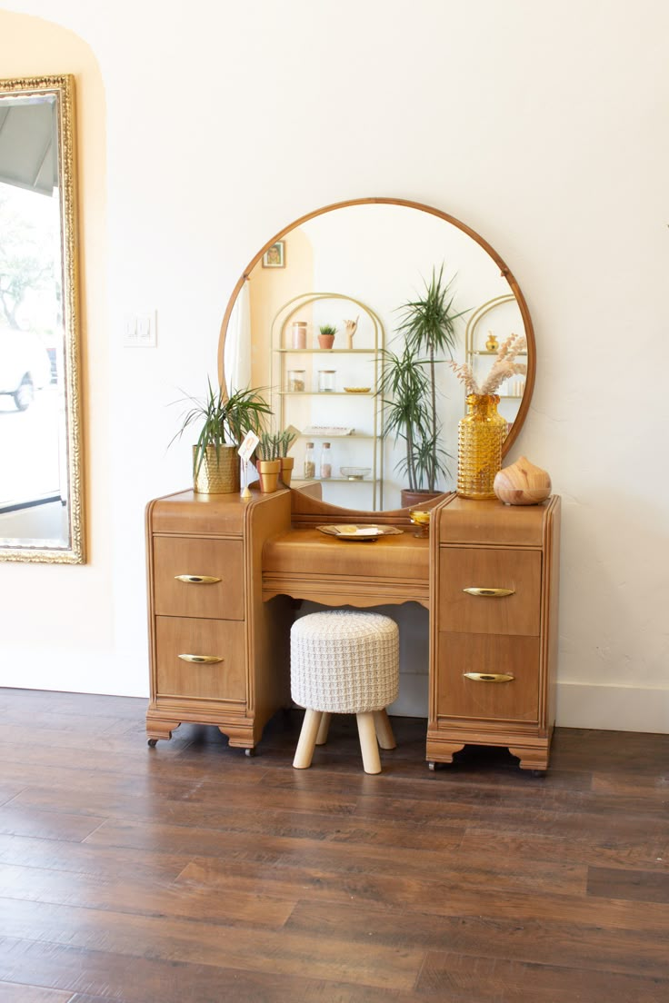 a wooden desk with a mirror and plant on it