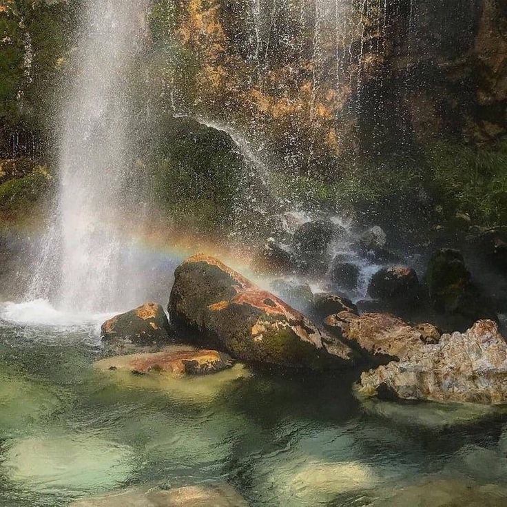 there is a rainbow in the water at this waterfall