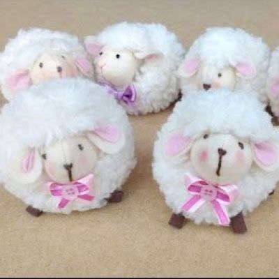 four white sheep with pink bows on their heads are sitting in the middle of a carpeted area