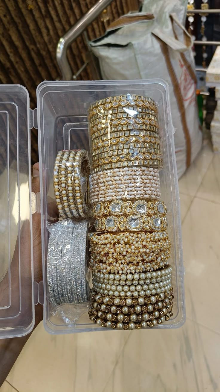 several bracelets are stacked on top of each other in a plastic container with clear lid