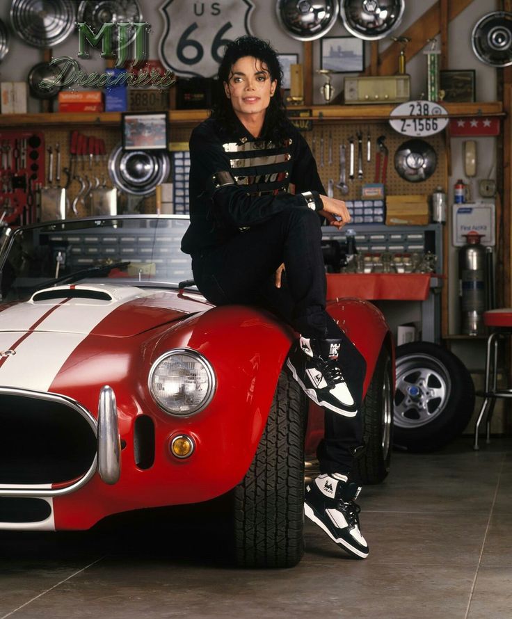 a woman sitting on top of a red and white car