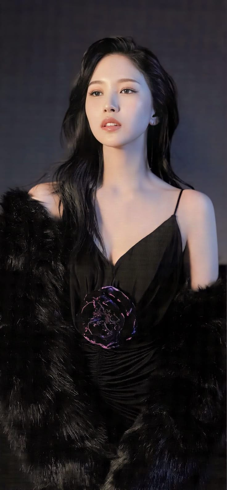 a woman with long black hair wearing a fur coat