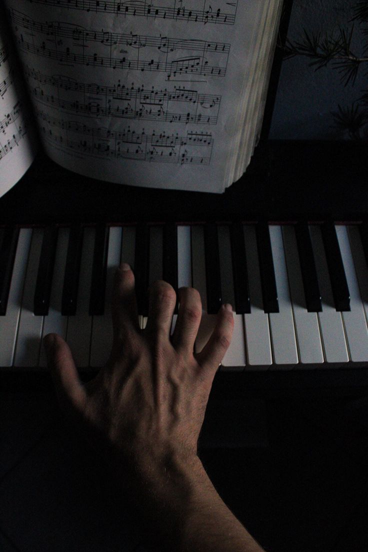 a person's hand on the keys of a piano