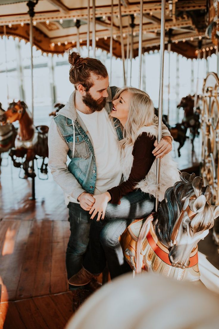 a man and woman on a merry go round at an amusement park with the caption google com