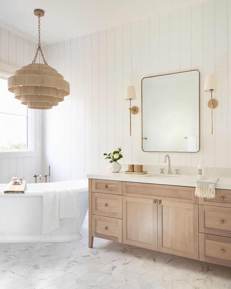 a bathroom with two sinks, a tub and a large mirror above the bathtub