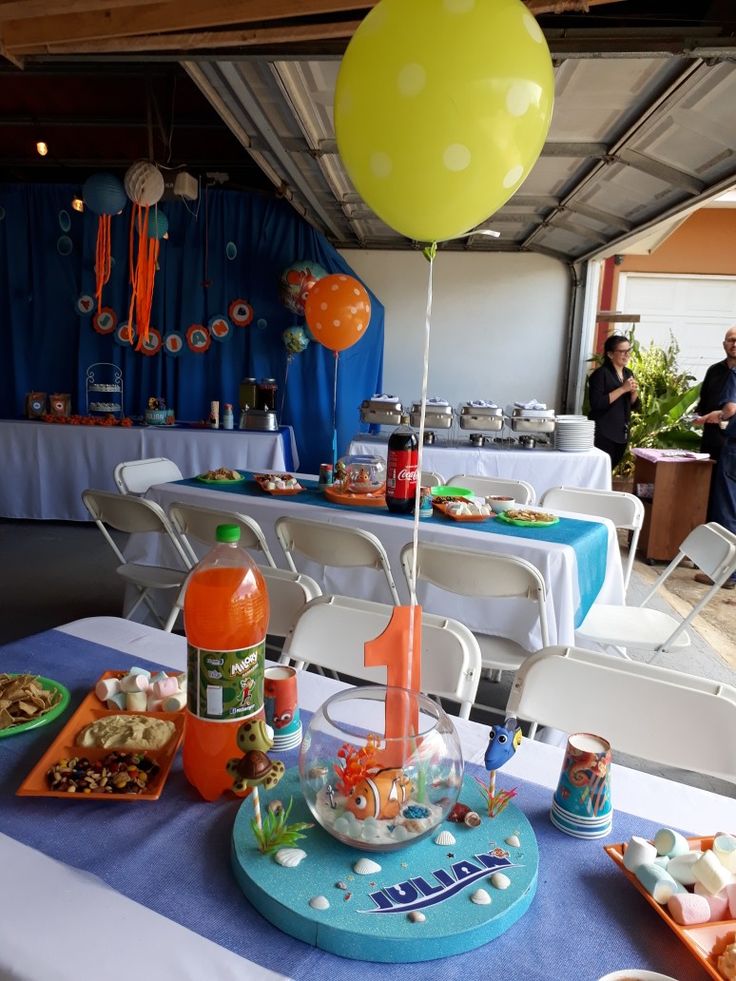 a table topped with lots of food and balloons