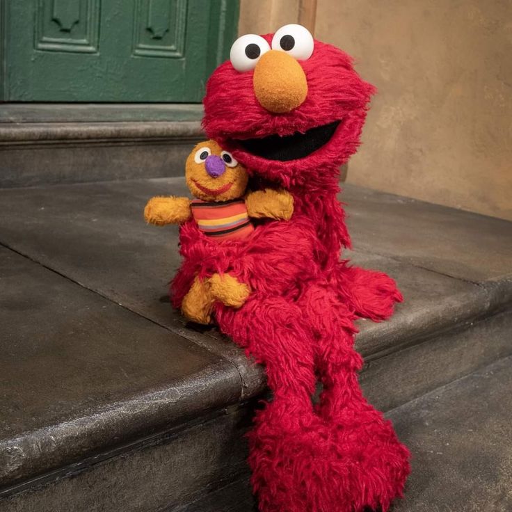 the sesame street character is holding his stuffed animal