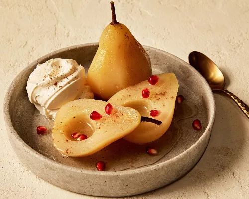 two pears and whipped cream in a bowl