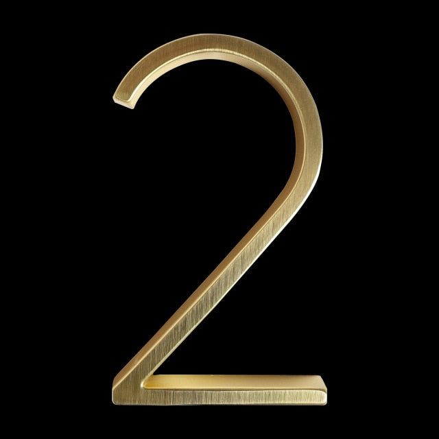 the number two is made out of gold metal and sits on a black background,