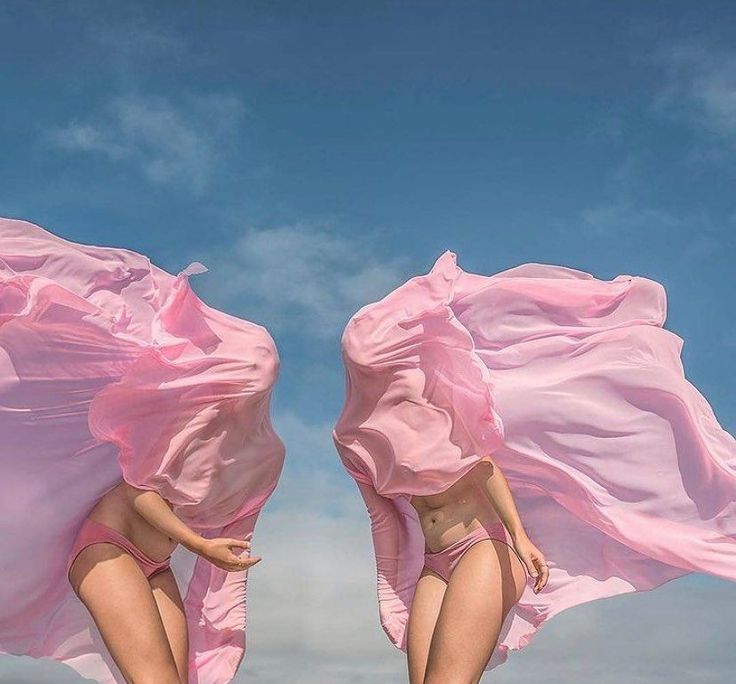 two women in pink swimsuits are flying through the air