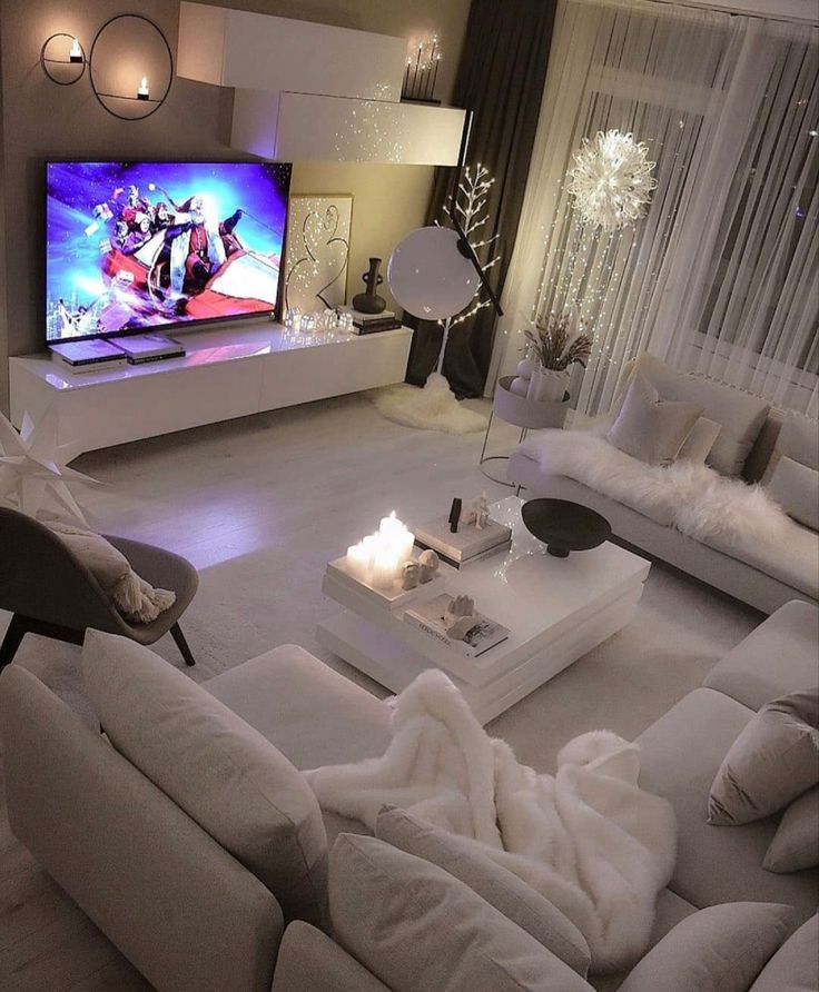 a living room filled with furniture and a flat screen tv on top of a wall