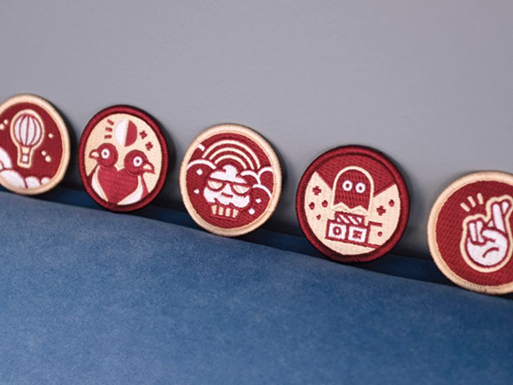 four wooden magnets with designs on them sitting in a row next to each other