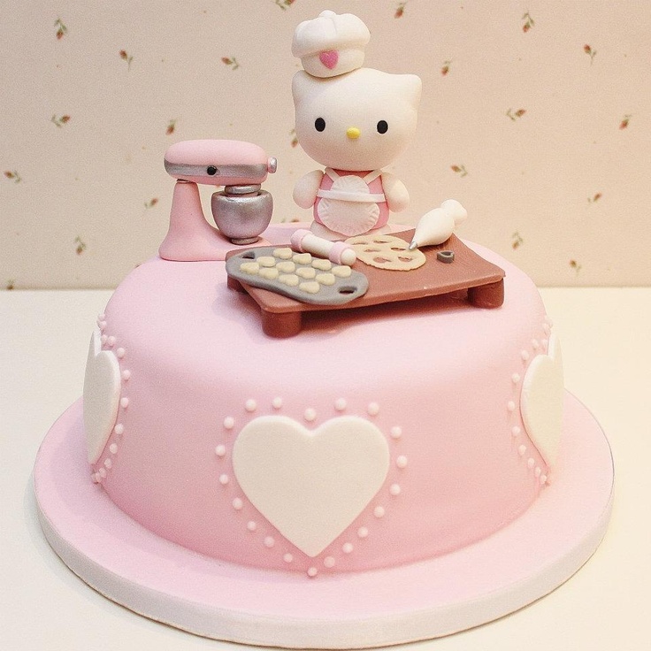 a hello kitty cake with a keyboard and mixer sitting on it's top tier