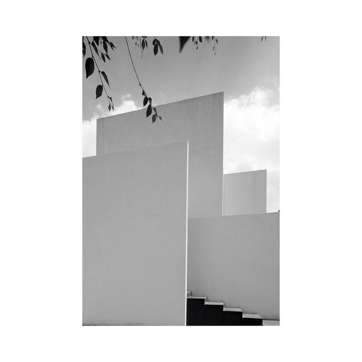 a white building with steps leading up to it's entrance and sky in the background