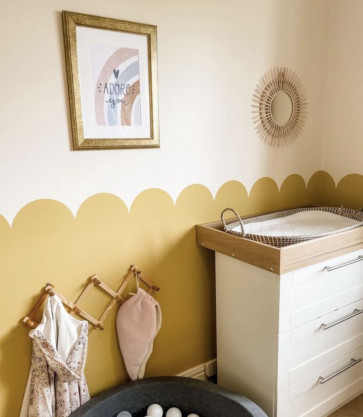 a baby's room with a crib, dresser and changing table in it