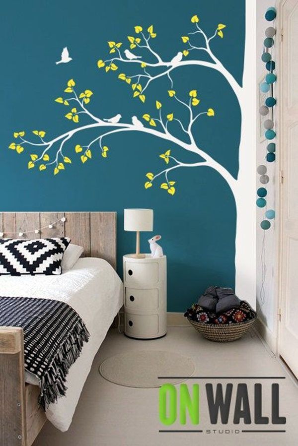 a bedroom with a tree painted on the wall